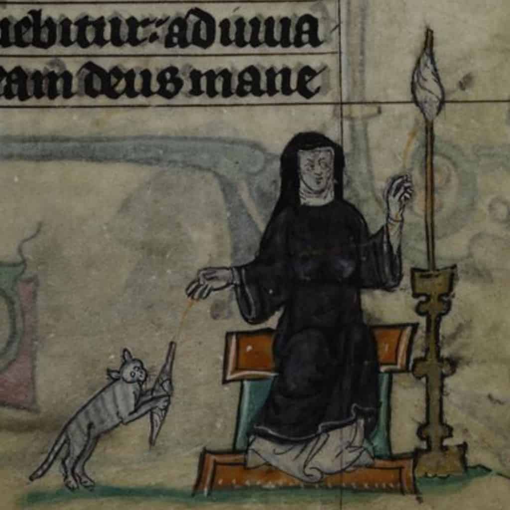 An illuminated manuscript depicting a monk with a cat catching a mouse in a candlelit scriptorium.